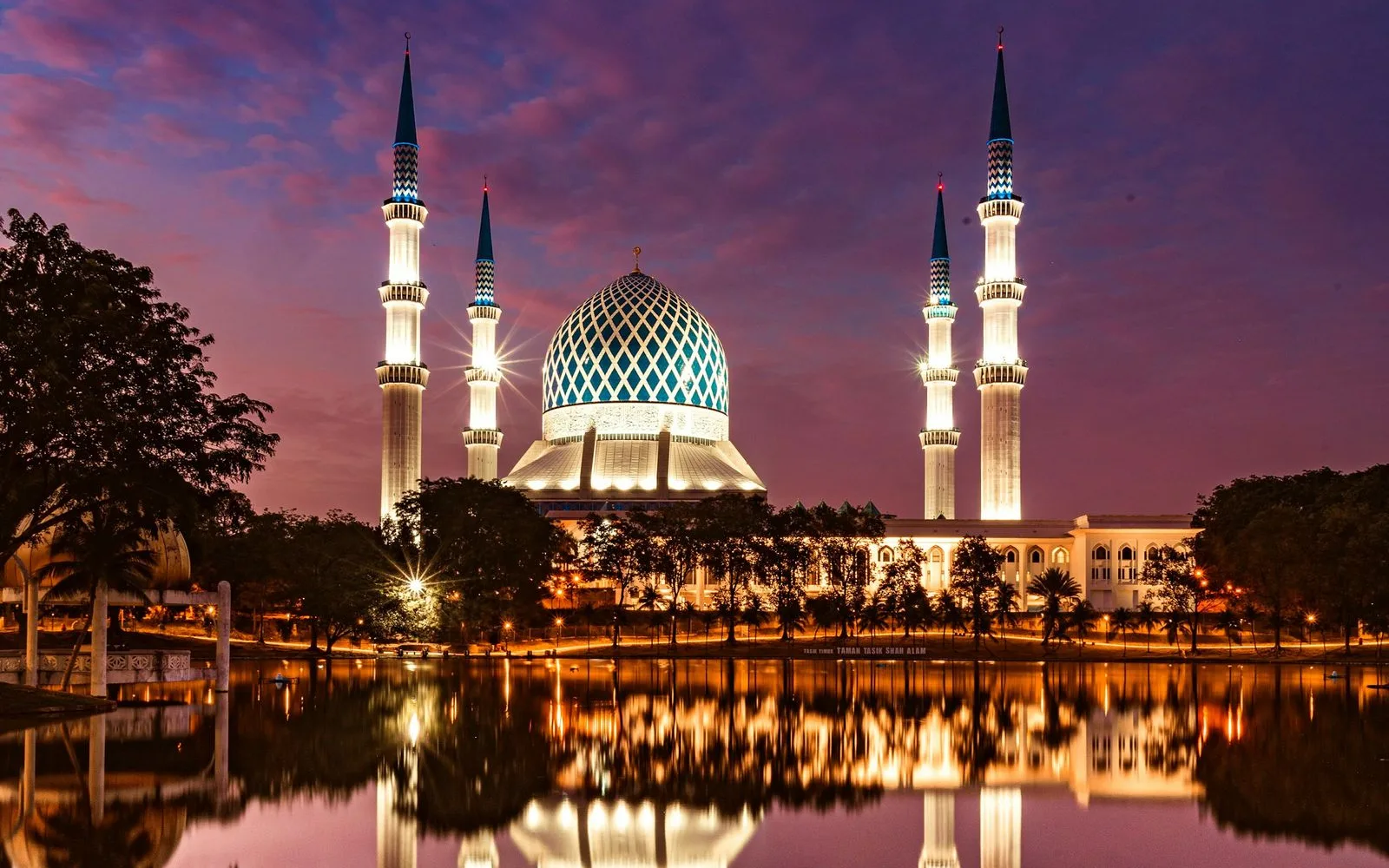 Sultan Salahuddin Abdul Aziz Shah Mosque in Shah Alam, Selangor, lit up at dusk and reflected in the lake Sultan Salahuddin Abdul Aziz Shah Mosque in Shah Alam, Selangor, lit up at dusk and reflected in the lake