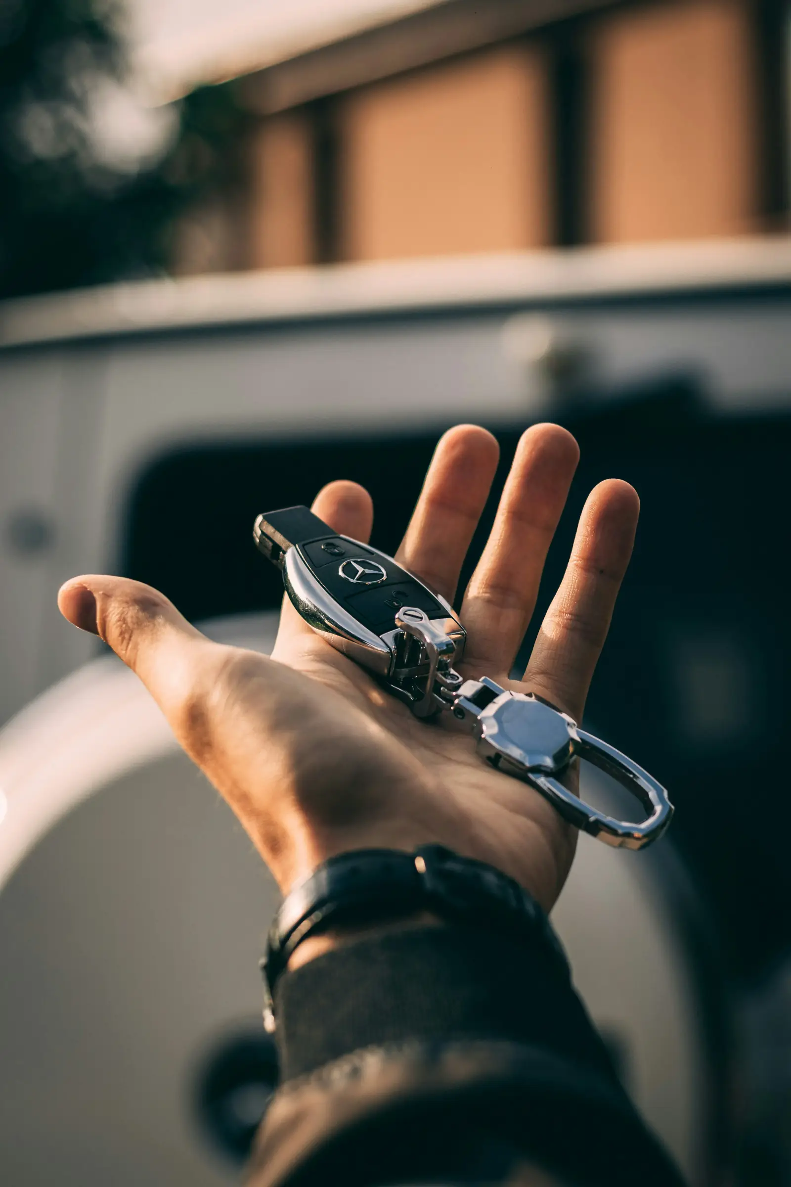 Hand holding a luxury car key for Maha Empire Car Rental Hand holding a luxury car key for Maha Empire Car Rental